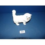 A white Beswick pottery cat standing by, having green eyes.