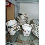 A part bone china Teaset with russet flowers and blue and green leaves comprising bread and butter