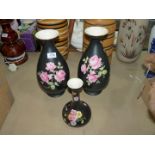 A pair of Crown Ducal Vases, black ground with pink roses plus one other.