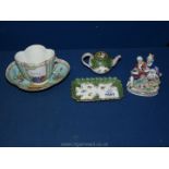 A Cup and saucer with romantic scenes to panels, AR mark to base, handle detached,