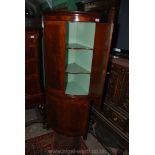 A reproduction cross-banded Mahogany bow fronted Corner Cupboard standing on splay bracket feet,