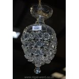 An elegant glass chandelier having a cut and polished glass dome with thumb cut details and with an