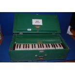 A table Organ in green case made by Bina.