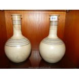 A pair of Christopher Dresser bottle vases in burnished terracotta with inlaid decoration and neck