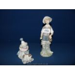 Two Lladro figures including a sitting down clown with puppy and a boy in fishing gear,