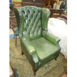 A green leather button back Wing Armchair