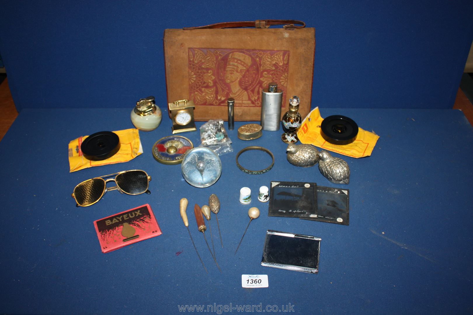 A box of miscellanea including a leather document holder, mini clock, films, lighter, etc.