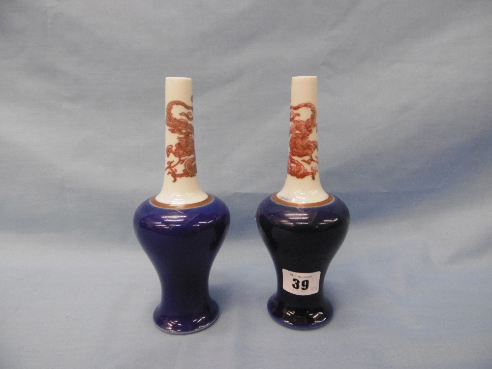 A pair of Chinese long neck vases with blue ground body, painted with red dragons,