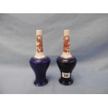 A pair of Chinese long neck vases with blue ground body, painted with red dragons,