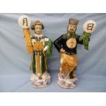 A pair of glazed oriental figures, possibly teracotta,