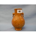 A brown Chinese vase with twin elephant mask handles and raised decoration of butterfly's,
