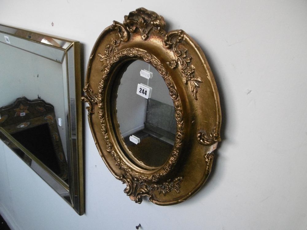 A gilt framed oval mirror, a.