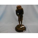 a bronze sculpture of a golfer