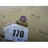An 18ct yellow gold crossover ring, set with a pink gem stone, possible a tourmaline ,