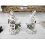 A pair of porcelain cherubs with derby style marks,