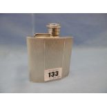 An art deco engine turned hallmarked silver hip flask with hinged cover,