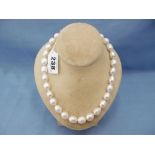 A south seas pearl necklace with 18ct gold clasp set with Cabochon ruby