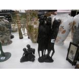 A carved African sculpture of four tribal people and a modern resin sculpture massi children