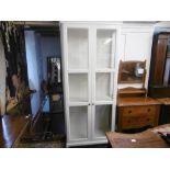 A decorative white two door display cabinet