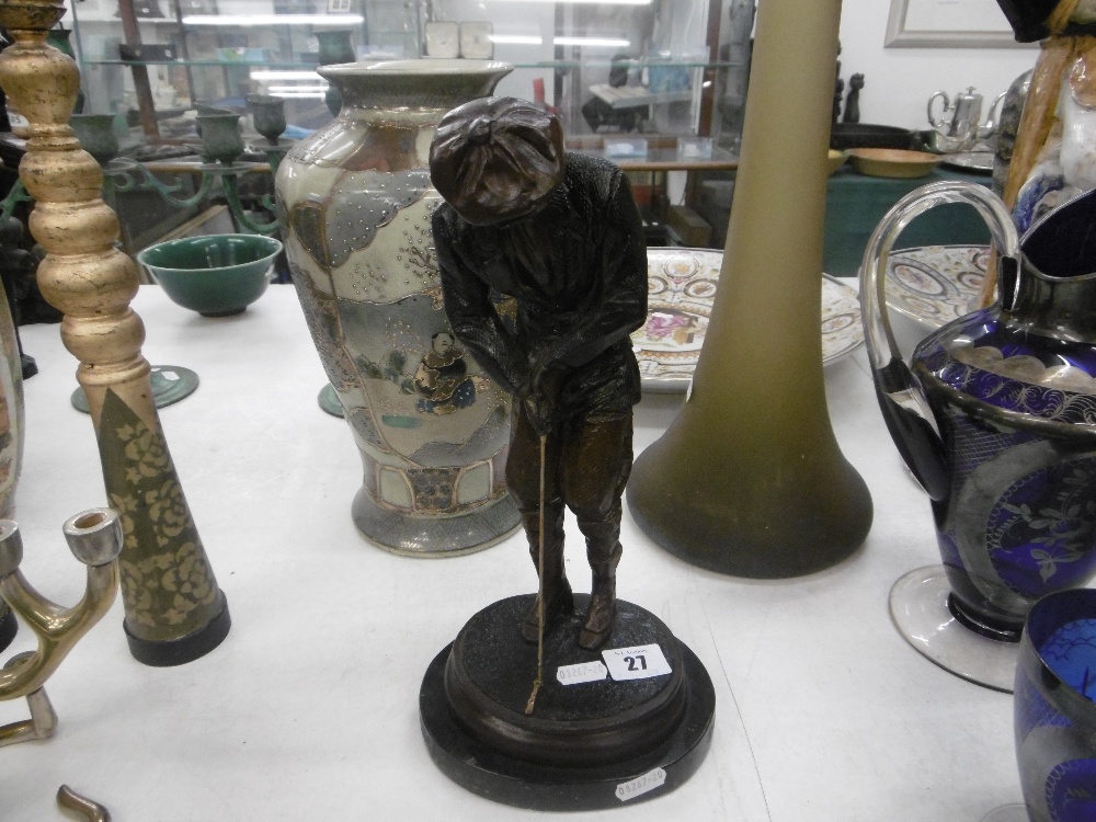 a bronze sculpture of a golfer