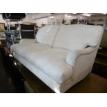 A WHITE UPHOLSTERED TWO SEATER SOFA