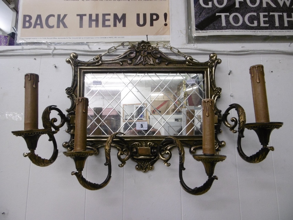 A French style brass four arm mirrored wall sconce