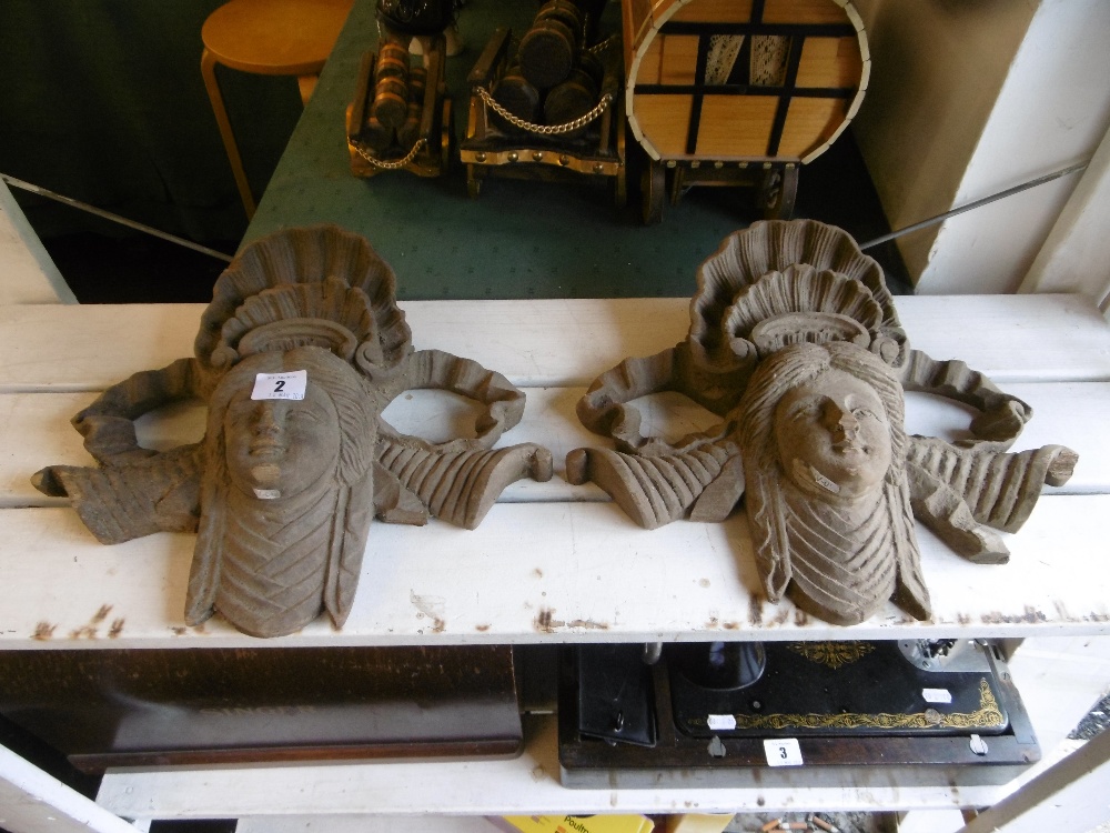 Two carved wood heads with shell decorations