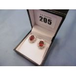 A pair of 18ct white gold treated ruby and diamond cluster stud earrings, total carat weight 5.
