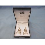 A pair of drop earrings set with diamonds and an oval pearl