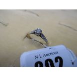 An 18ct gold diamond and solitaire ring with diamond shoulders,