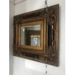 A gilt framed ornamental mirror