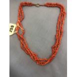 A three strand coral necklace with rose metal clasp