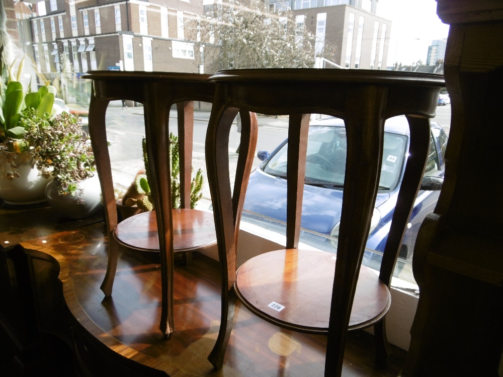 A pair of circular two tier occasional tables