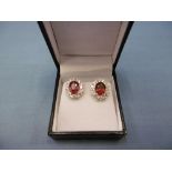 A pair of 18ct white gold treated ruby and diamond cluster stud earrings, total carat weight 5.