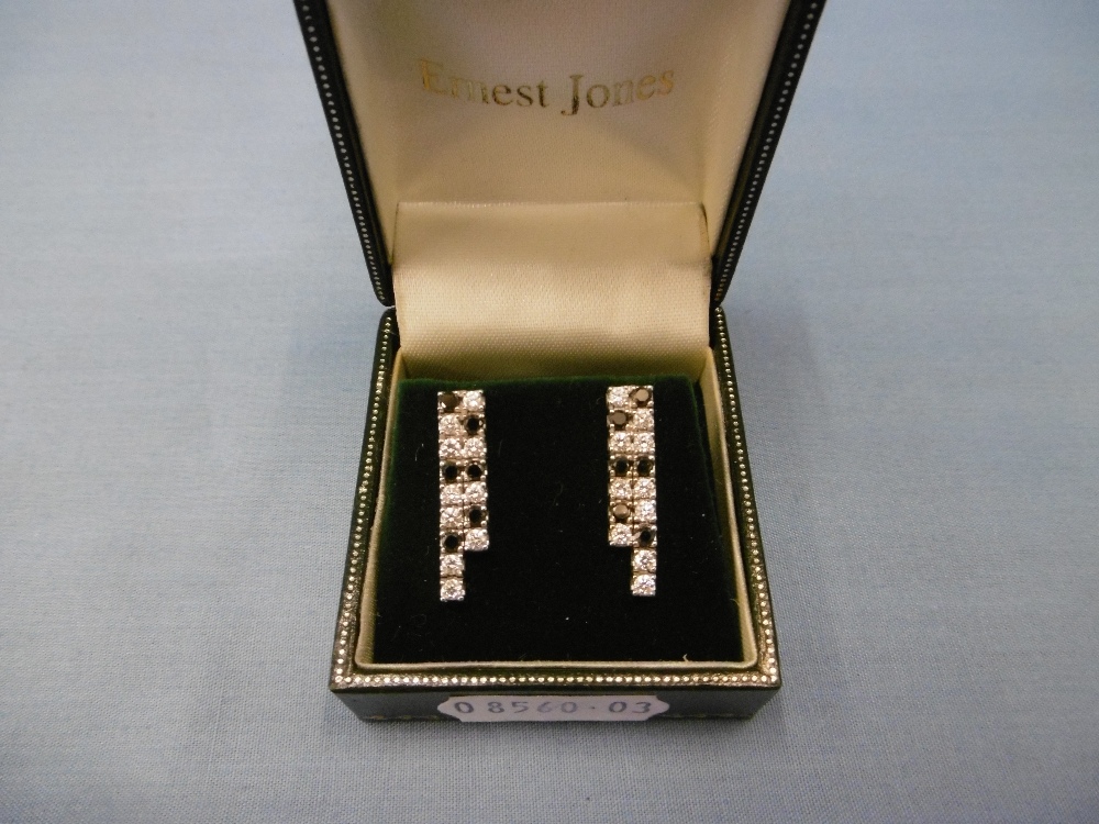 A pair of white gold black and white diamond earrings