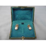 A pair of pearl drop earrings set with diamond bow tops