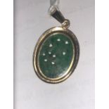 An indistinctly marked yellow metal and jade pendant,