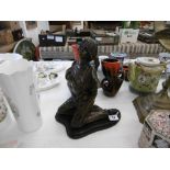 A bronze sculpture of a kneeling lady on marble plinth