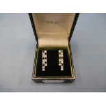 A pair of white gold black and white diamond earrings