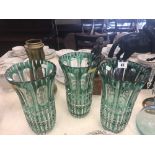 A set of three green overlay cut glass vases