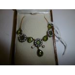 A yellow metal and silver peridot and pearl necklace