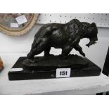A small bronze sculpture of bear with salmon in its mouth