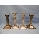 A pair of hallmarked silver filled Corinthian column candlesticks and a silver plated pair of