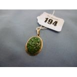 An indistinctly marked yellow metal and jade pendant,