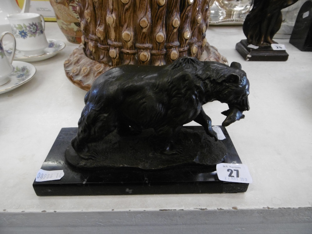 A small bronze sculpture of bear with salmon in its mouth