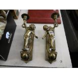 A pair of brass wall sconces with cherubs