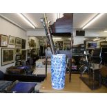 A blue and white umbrella stand with three walking sticks