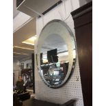 An oval etched glass mirror