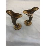 A pair of hallmarked silver dolphin spill vases