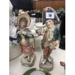 A pair of glazed pottery figures in 18th Century costume both damaged